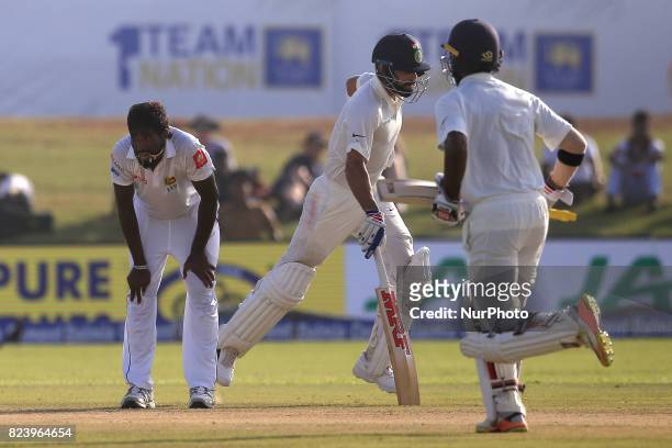 Sri Lankan cricketer Nuwan Pradeep reacts as Indian cricket captain and Indian cricketer Abhinav Mukund run between the wickets during the 3rd Day's...