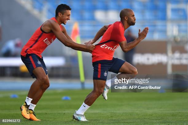 Paris Saint-Germain's Brazilian defender Marquinhos and Paris Saint-Germain's Brazilian midfielder Lucas Moura take part in a training session at the...