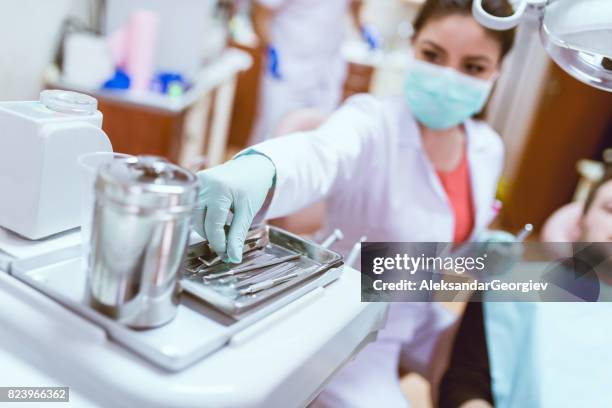 vrouwelijk tandarts met instrumenten behandeling van jonge mannelijke patiënt - dental explorer stockfoto's en -beelden