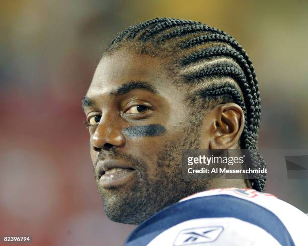 Wide receiver Randy Moss of the New England Patriots watches play against the Tampa Bay Buccaneers at Raymond James Stadium on August 17, 2008 in...