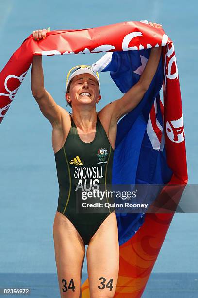 Emma Snowsill of Australia celebrates as she crosses the finish line to take the gold medal in the women's triathlon event at the Triathlon Venue on...