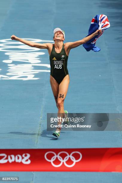 Emma Snowsill of Australia celebrates prior to crossing the finish line to take the gold medal in the women's triathlon event at the Triathlon Venue...