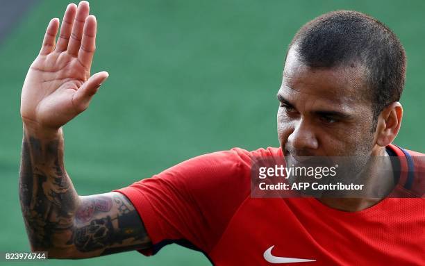 Paris Saint-Germain's Brazilian defender Dani Alves waves at the end of a training session at the Grand Stade in Tangiers on July 28, 2017 on the eve...