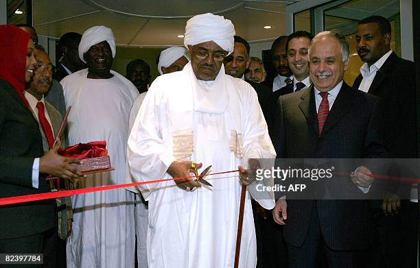 Sudanese President Omar al-Beshir cuts the ribbon as Libya's Prime Minister Baghdadi Mahmudi stands next to him during the inauguration of Burj...