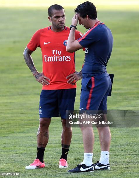 Paris Saint-Germain's Spanish coach Unai Emery speaks to Paris Saint-Germain's Brazilian defender Dani Alves during a training session at the Grand...