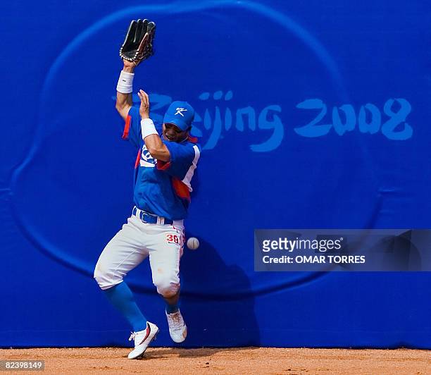 South Korea's centerfielder Lee Jong-wook crashes into the wall after failing to catch a fly ball in the bottom of the seventh inning of their men's...
