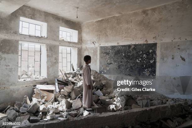 Student at the Aal Okab school stands in the ruins of one of his former classrooms, which was destroyed during the conflict in June 2015. Students...