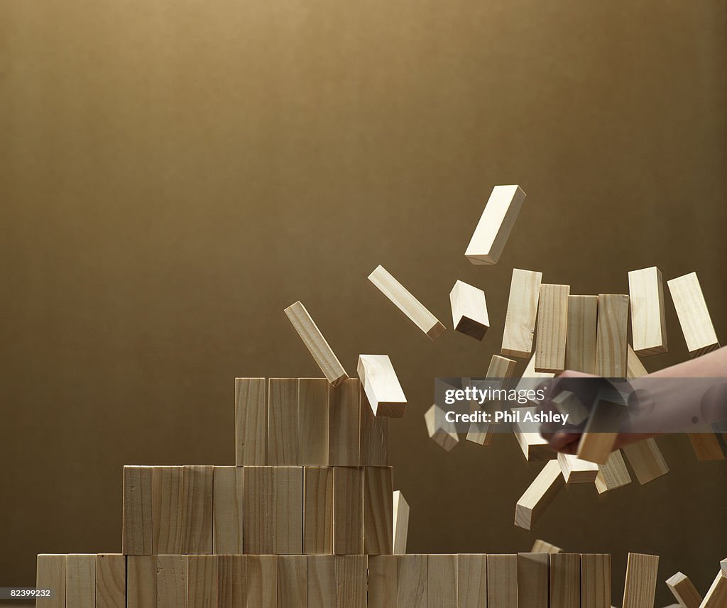 Woman smashing a stack of wooden blocks