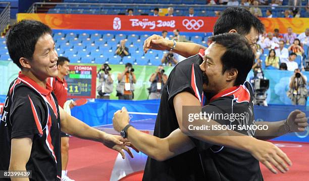 Jae Young Yoon , Sang Eun Ho and their coach Soo Kim Taek celebrate after their teammate Seung Min Ryu defeated Austria's Chen Weixing in their...