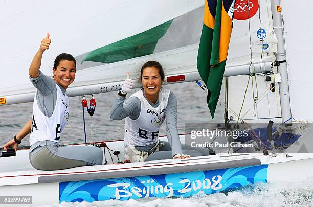 Isabel Swan and Fernanda Oliveira of Brazil celebrate after finishing third overall following the Women's 470 class medal race held at the Qingdao...