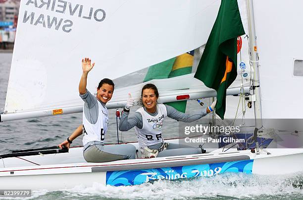 Isabel Swan and Fernanda Oliveira of Brazil celebrate after finishing third overall following the Women's 470 class medal race held at the Qingdao...