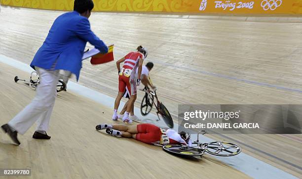 Track cyclist Satomi Wadami of Japan lies beside the track after suffering an accident with Denmark's Trine Schmidt and Sarah Hammer of the US in the...