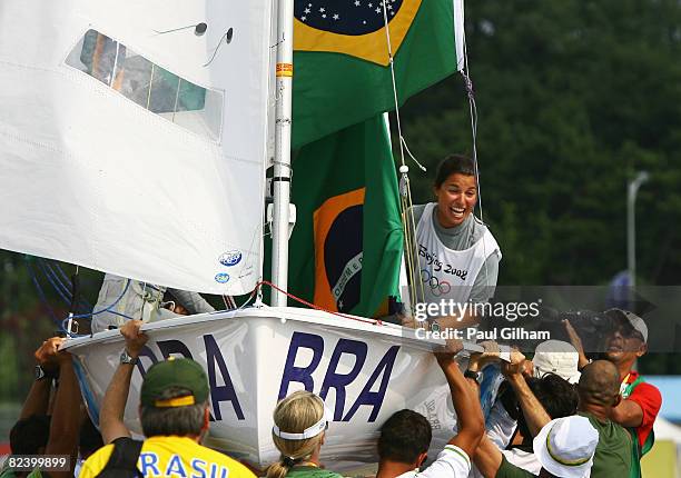 Fernanda Oliveira and Isabel Swan of Brazil celebrate with team officials and friends after finishing third overall following the Women's 470 class...