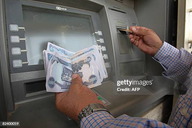 User withdraws money from the Iraqi Warka Bank ATM in Ghelan Square in central Baghdad on August 18, 2008. This machine, one of the few working in...