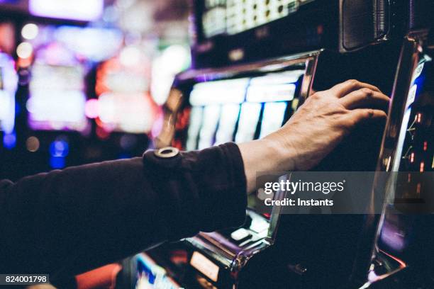 hand of a 59 year old woman playing a slot machine in one of las vegas casinos. - fruit machine stock pictures, royalty-free photos & images