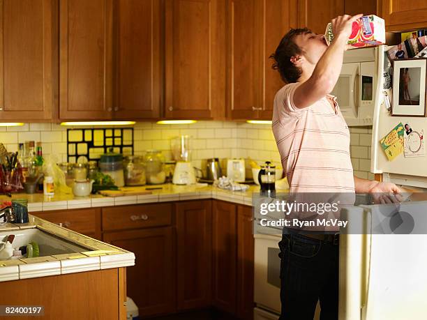 young man driking juice out of the carton - juice box stock pictures, royalty-free photos & images