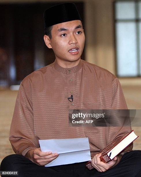 Malaysian opposition leader Anwar Ibrahim's former aide, Mohd Saiful Bukhari Azlan holds the Quran while he takes an oath at a mosque in Kuala Lumpur...