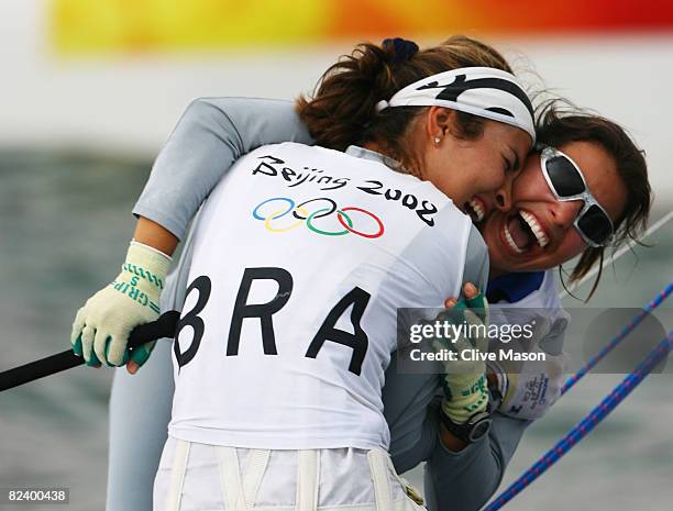 Fernanda Oliveira of Brazil celebrates with team mate Isabel Swan after they finished third overall in the Women's 470 class event held at the...