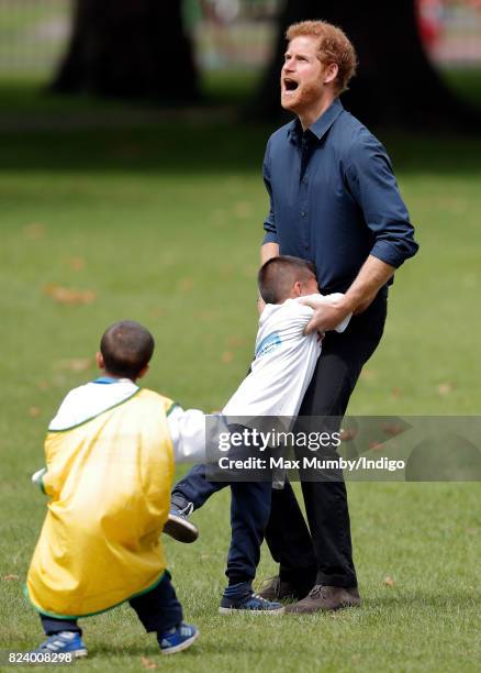 Prince Harry plays handball with children taking part in a StreetGames 'Fit and Fed' summer holiday activity session in Central Park, East Ham on...