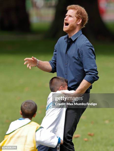 Prince Harry plays handball with children taking part in a StreetGames 'Fit and Fed' summer holiday activity session in Central Park, East Ham on...