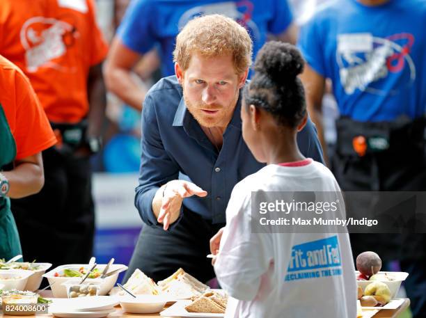 Prince Harry serves lunch to children taking part in a StreetGames 'Fit and Fed' summer holiday activity session in Central Park, East Ham on July...