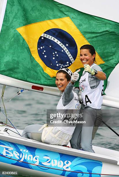 Fernanda Oliveira and Isabel Swan of Brazil celebrate after they finished third overall in the Women's 470 class event held at the Qingdao Olympic...