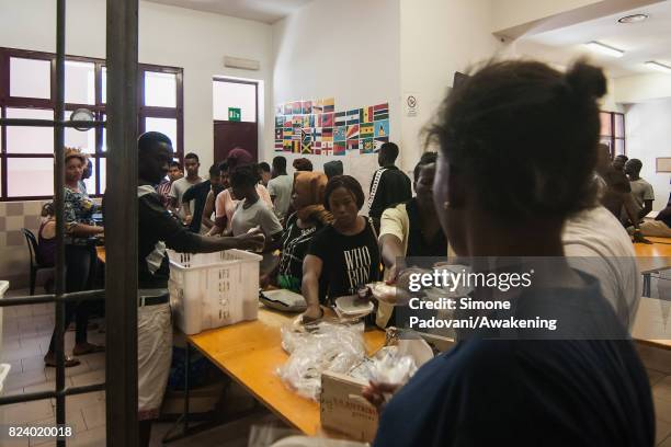 Asylum seekers take their lunch provided by staff, the Hub centre feed nearly 1000 asylum seekers per day on July 27, 2017 in Bologna, Italy. In an...