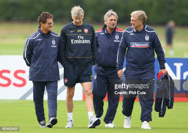 England manager Fabio Capello, Arsenal manager Arsene Wenger, Franco Baldini, England General Manager and Sir Trevor Brooking walk off the pitch...