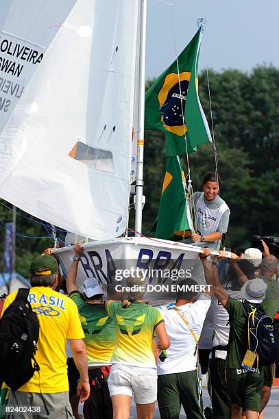 Sailor Fernanda Oliveira of Brazil of the 470 women's class is lifted in her boat as she celebrates her bronze medal place at the 2008 Beijing...