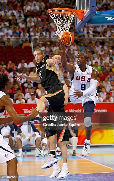 Dwyane Wade of the United States drives to the basket over the defense of Tim Ohlbrecht of Germany during the men?s basketball preliminaries at the...