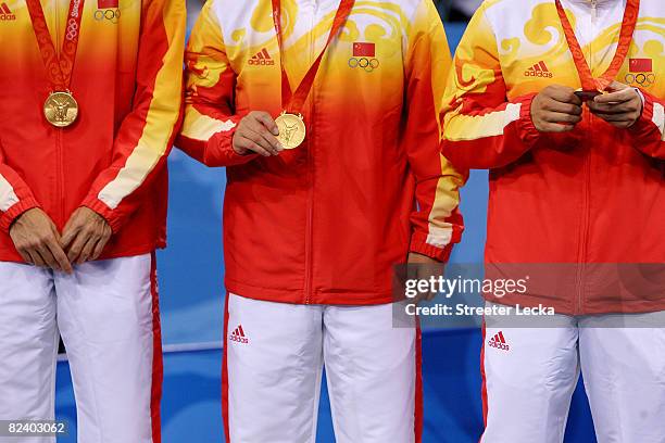 Ma Lin, Wang Hao and Wang Liqin of China celebrate their gold medal in the Men's Team Contest at the Peking University Gymnasium on Day 10 of the...