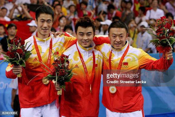 Ma Lin, Wang Hao and Wang Liqin of China celebrate their gold medal in the Men's Team Contest at the Peking University Gymnasium on Day 10 of the...