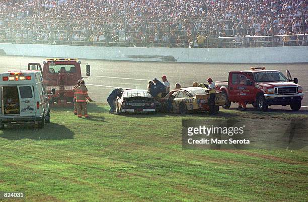 Rescue workers arrive at Dale Earnhardt's Goodwrench Chevrolet after a crash during the running of the 43rd Daytona 500 at the Daytona International...