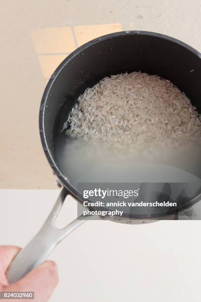 basmati rice and water in cooking pan. - basmati rice stock pictures, royalty-free photos & images