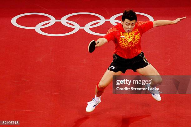 Hao Wang of China hits a shot during the Men's Team Contest against Germany at the Peking University Gymnasium on Day 10 of the Beijing 2008 Olympic...