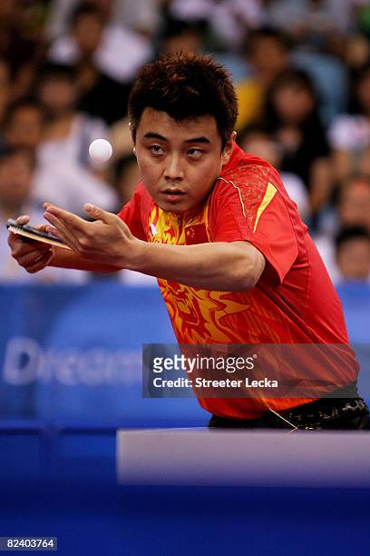 Hao Wang of China hits a shot during the Men's Team Contest against Germany at the Peking University Gymnasium on Day 10 of the Beijing 2008 Olympic...