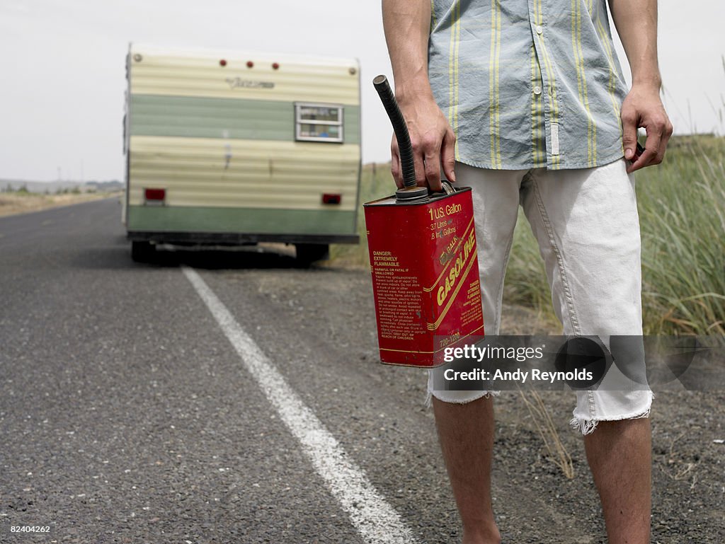 Man with gas can, trailer behind