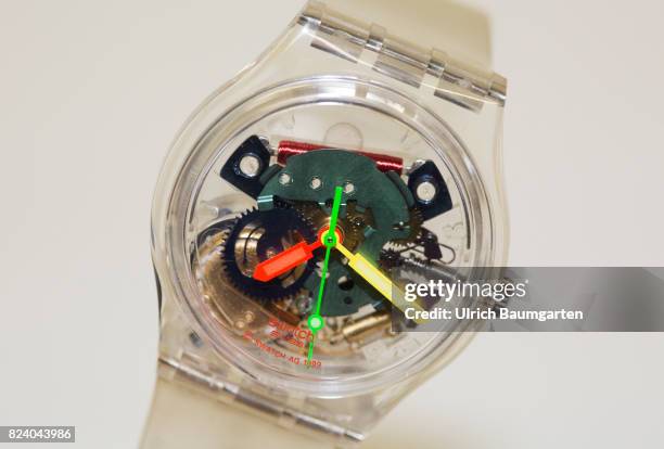 The photo shows the clockwork and the clock hands of a transparent wrist watch.