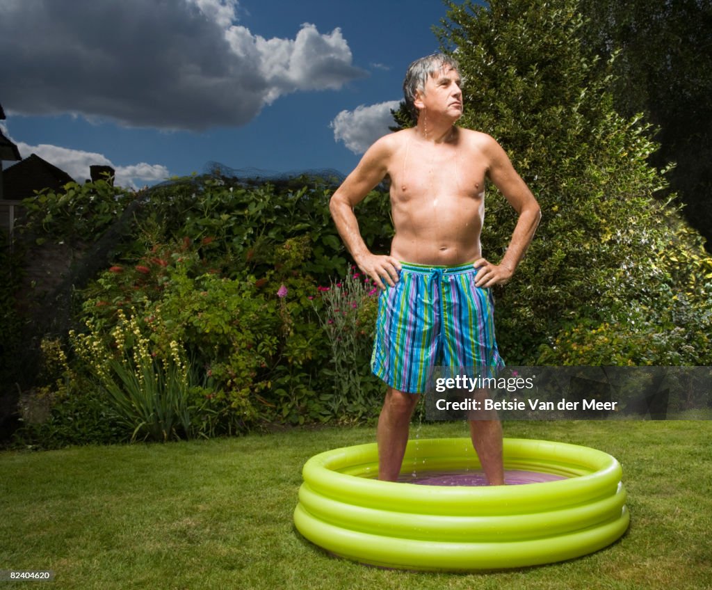 Mature man standing in paddlingpool.