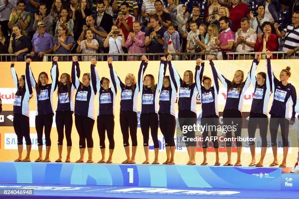 Players celebrate on the podium after winning the women's final water polo match between USA and Spain during the FINA2017 world championships, on...