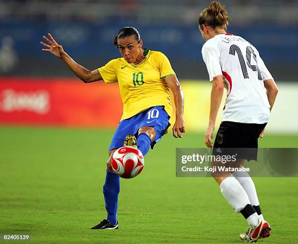 Marta of Brazil passes the ball past Simone Laudehr of Germany during the Women's Semi Final match between Brazil and Germany at Shanghai Stadium on...