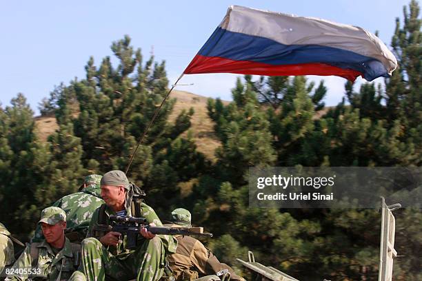 Russian soldiers sit on top of an Armoured Personnel Carrier flying their flag at a Russian army position on August 18, 2008 just outside the town of...