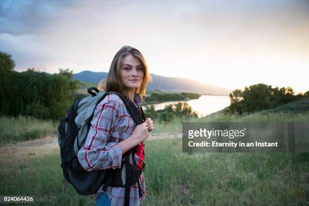 young woman hiking in the mountains - rucksacktourist stock-fotos und bilder