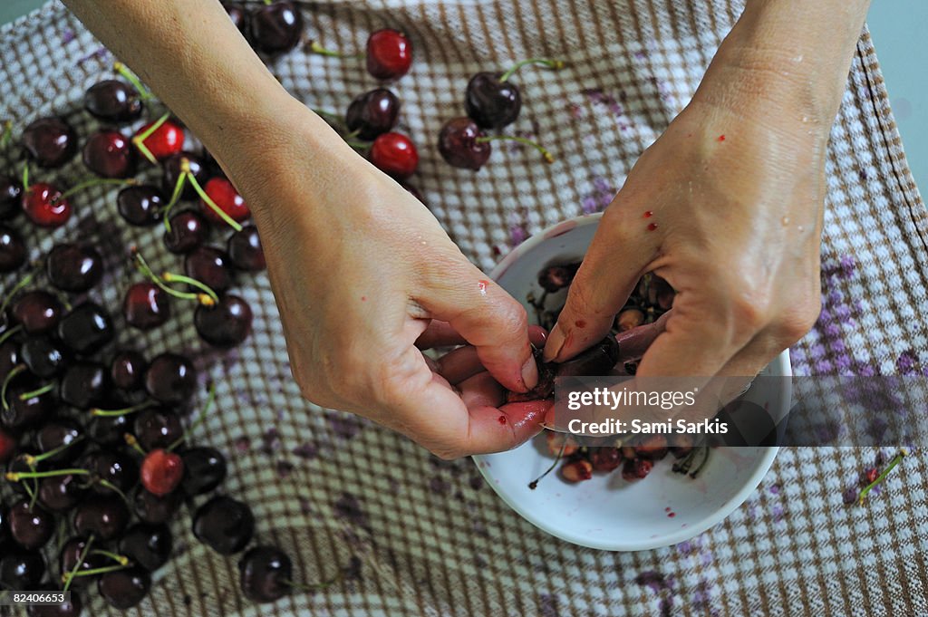 Woman removing pits from cherries