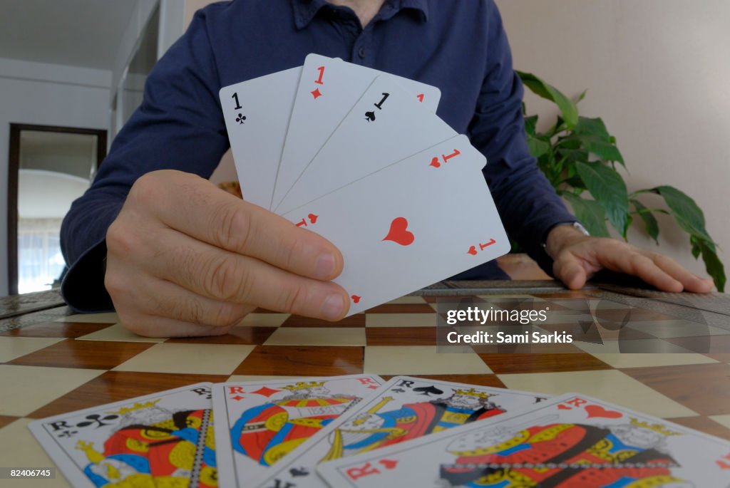 Man playing cards, showing four aces