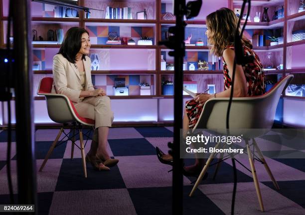 Sheryl Sandberg, chief operating officer of Facebook Inc., left, smiles during a Bloomberg Studio 1.0 television interview at Facebook headquarters...