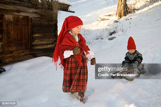 two children with sled in snow - christmas norway stock pictures, royalty-free photos & images