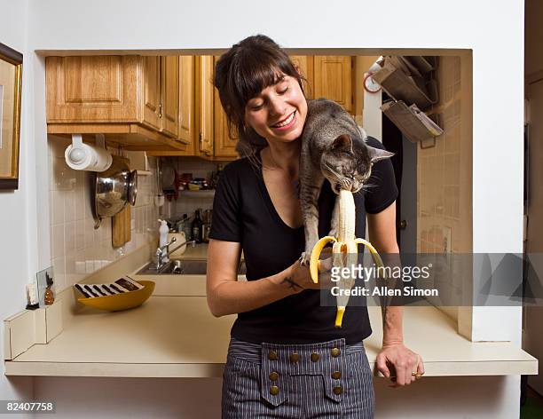 cat eating banana on woman's shoulder - woman eating fruit stock pictures, royalty-free photos & images