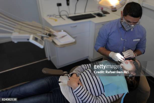 dentist examining a patient - surgical loupes stock pictures, royalty-free photos & images
