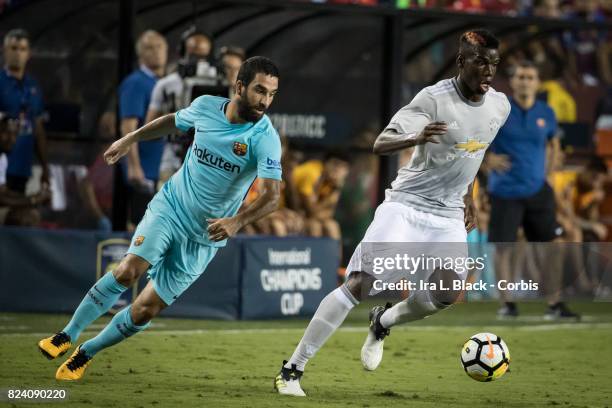 Paul Pogba of Manchester United breaks away from Arda Turan of Barcelona during the International Champions Cup match between FC Barcelona and...